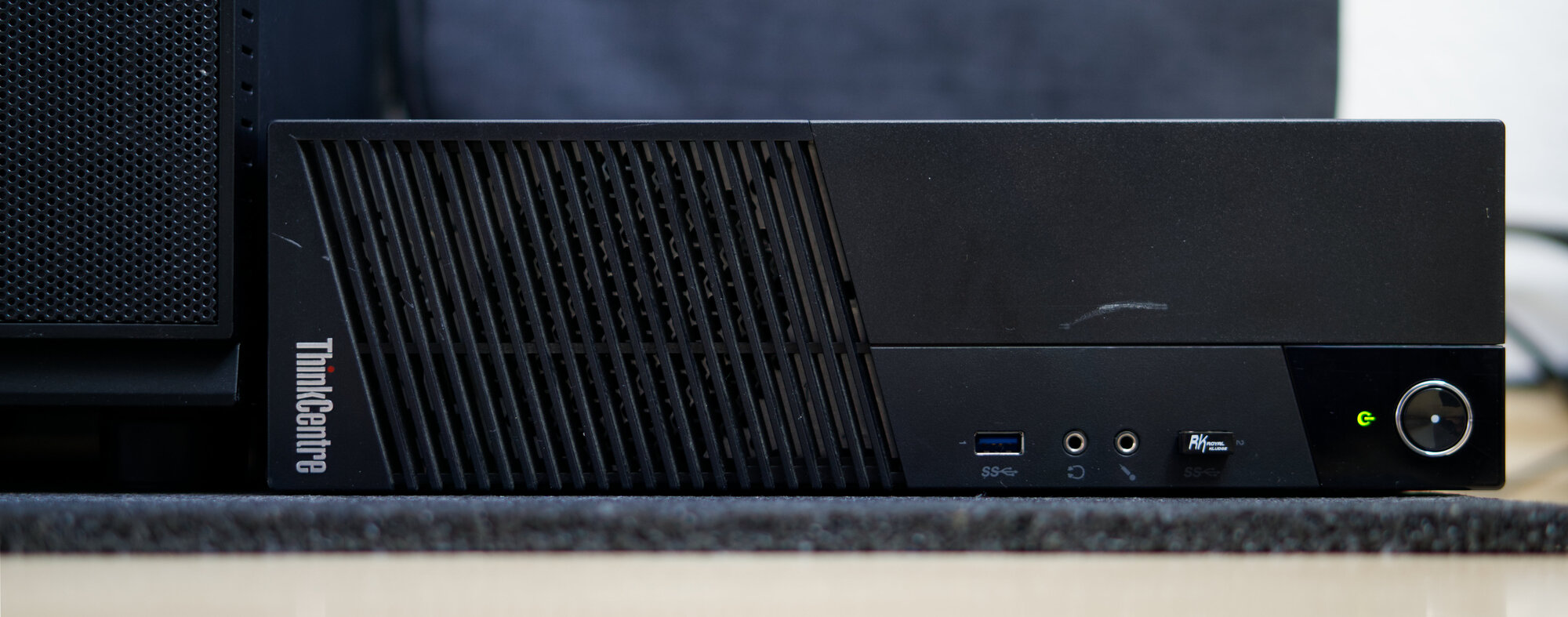 A photo of a ThinkCentre M93p SFF lying horizontally on the ground. The photo shows the front of the PC.